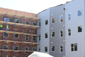 Construction workers on scaffolding beside building